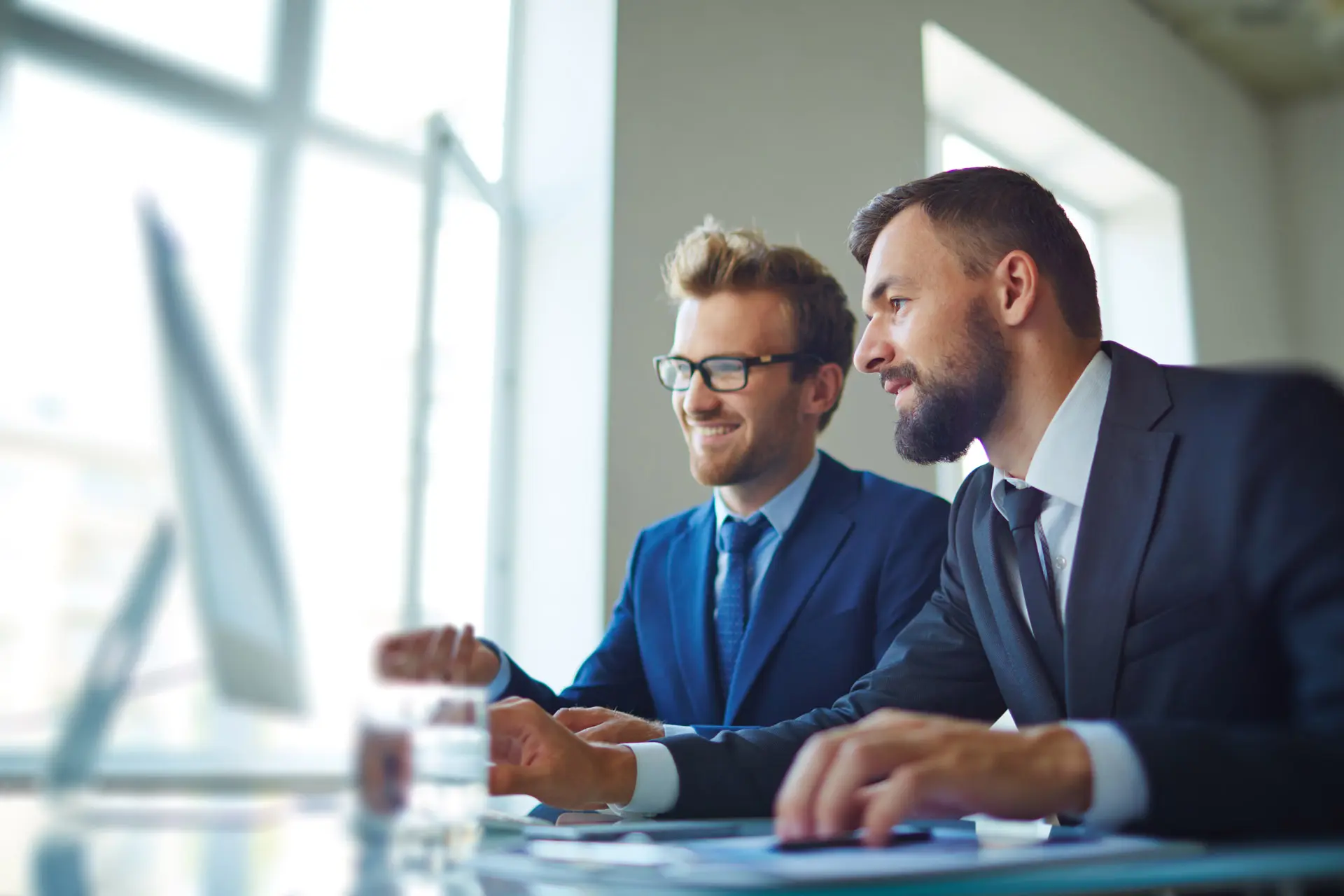 Two consultants from Clear Cut Consultants sitting at a computer and coming up with a financial plan